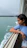 Smiling woman enjoying a boat tour with turquoise sea in the background