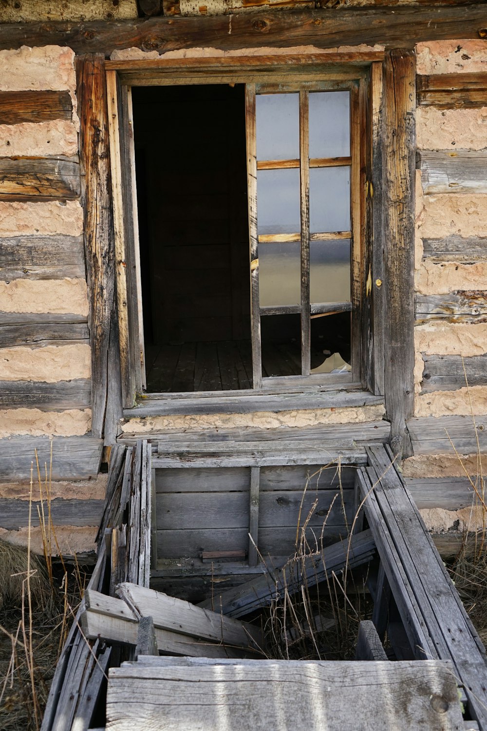 a broken window in an old log cabin