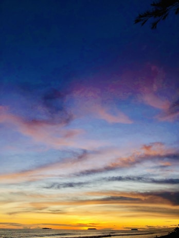 A vibrant sunset over the ocean, highlighting the beauty of Nusa Penida's coastline.