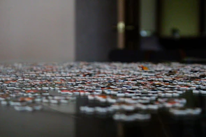 Close-up of colorful 3D printed puzzle pieces scattered on a cozy wooden table.
