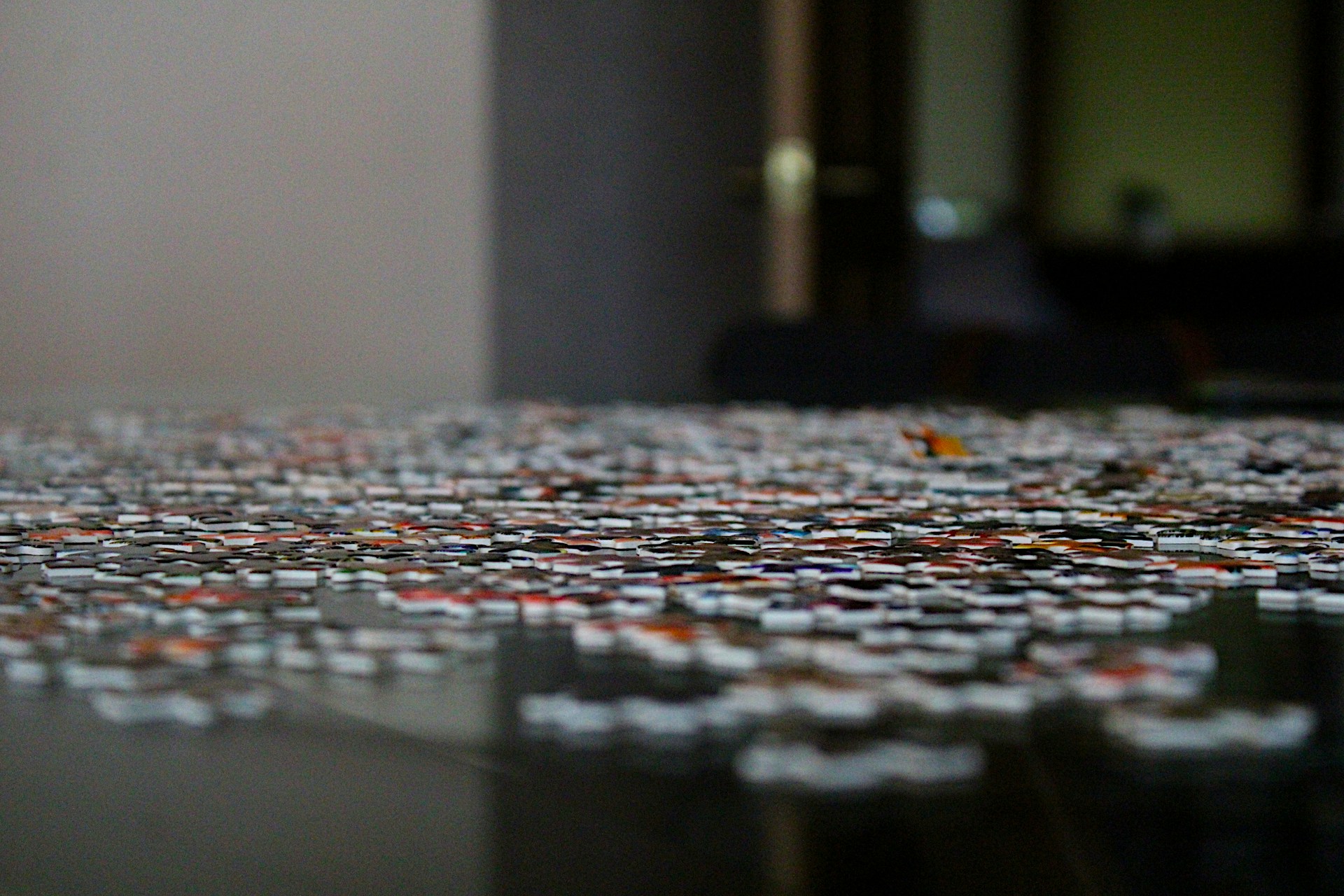A close-up of colorful puzzle pieces fitting together on a wooden table, representing the new pastime invented by numego.