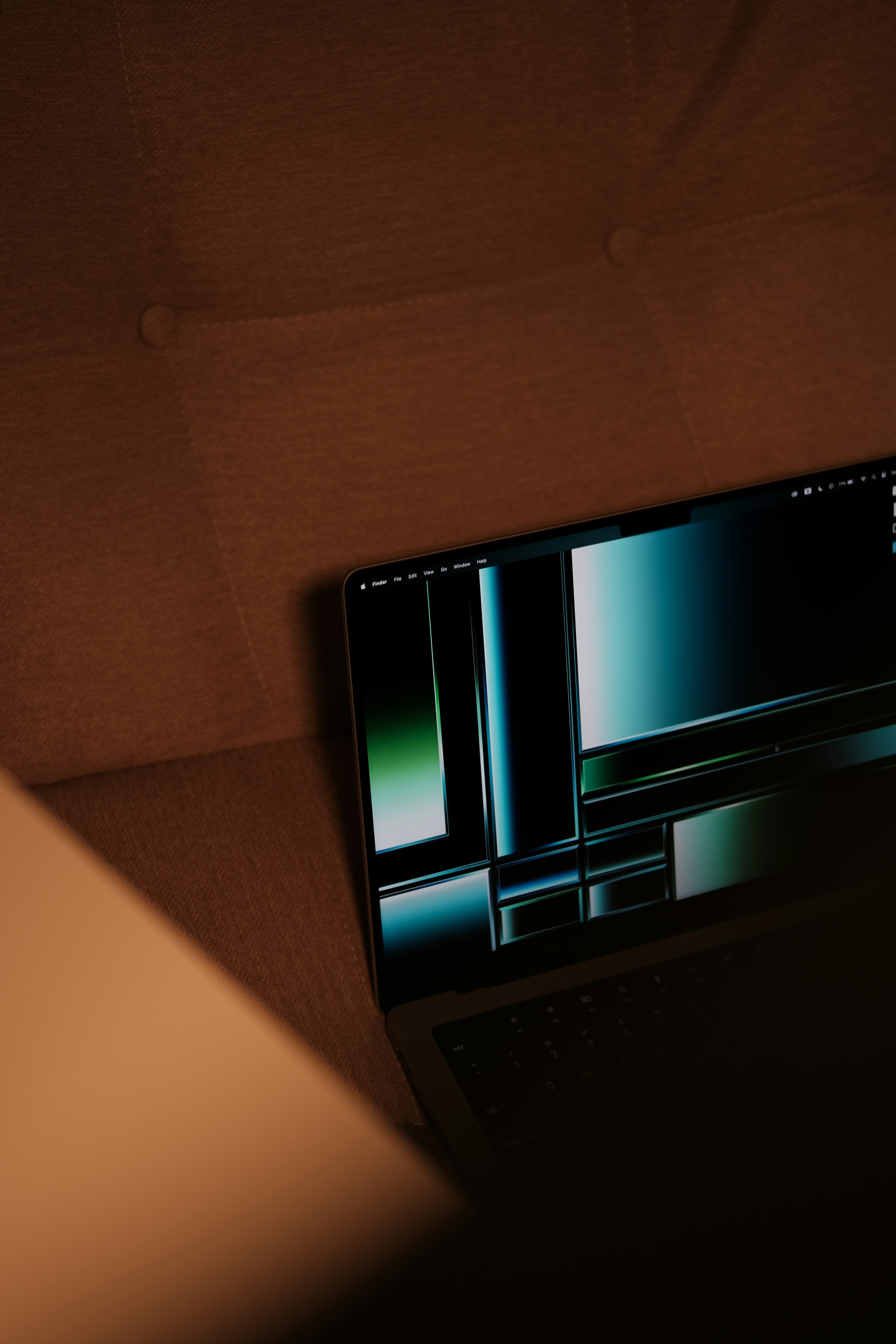 a laptop computer sitting on top of a brown couch