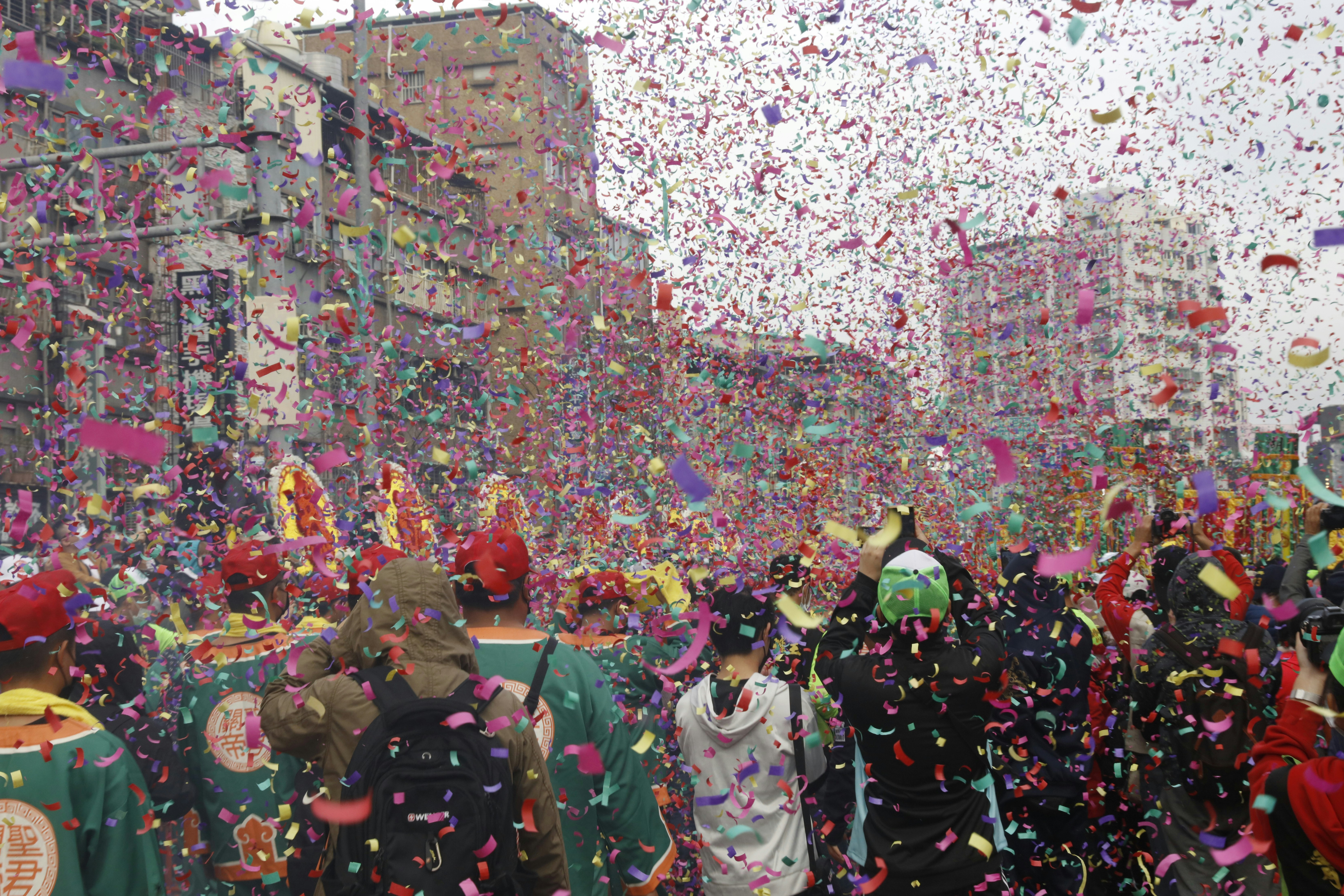 a group of people walking down a street surrounded by confetti