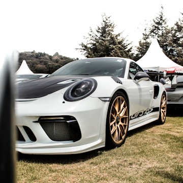 A sleek sports car parked beside a famous influencer during a collaboration event.