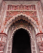 a large ornate doorway with a clock on it's side