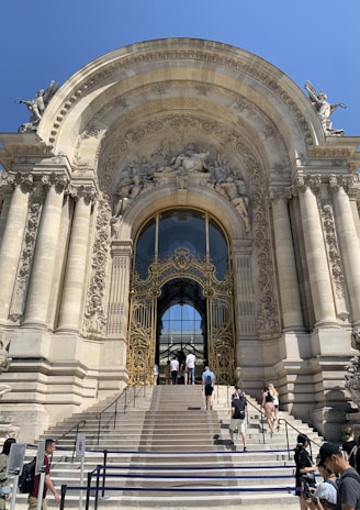 An imposing entrance to a luxury building, framed by bold columns and subtle gold highlights.