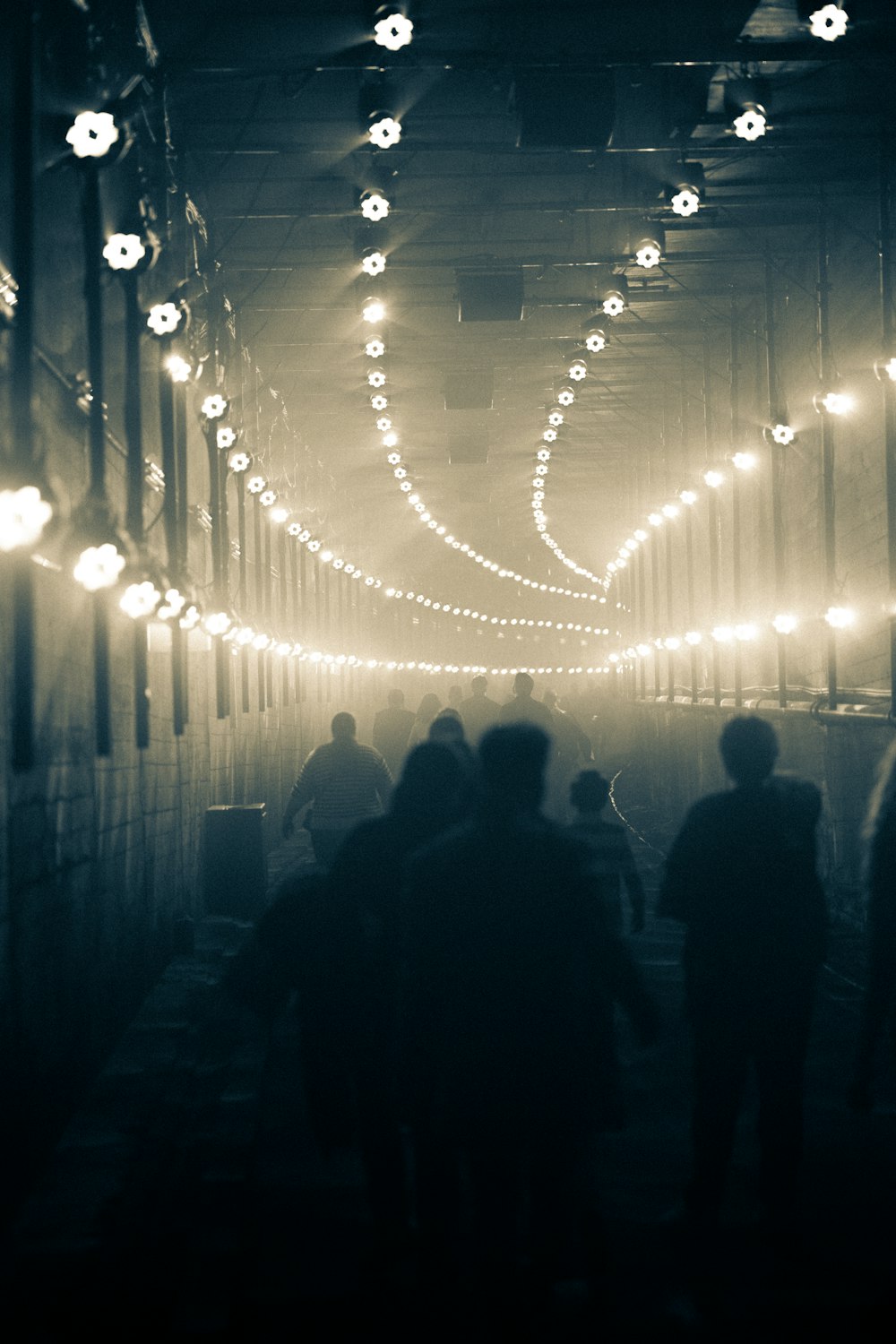 um grupo de pessoas caminhando por um túnel escuro