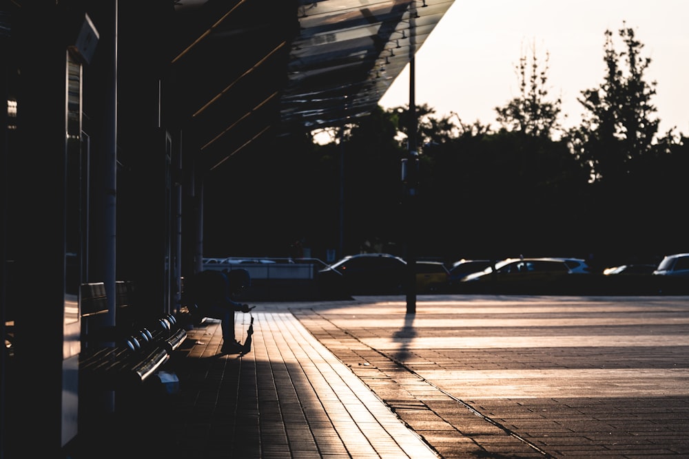 a person walking down a sidewalk next to a building