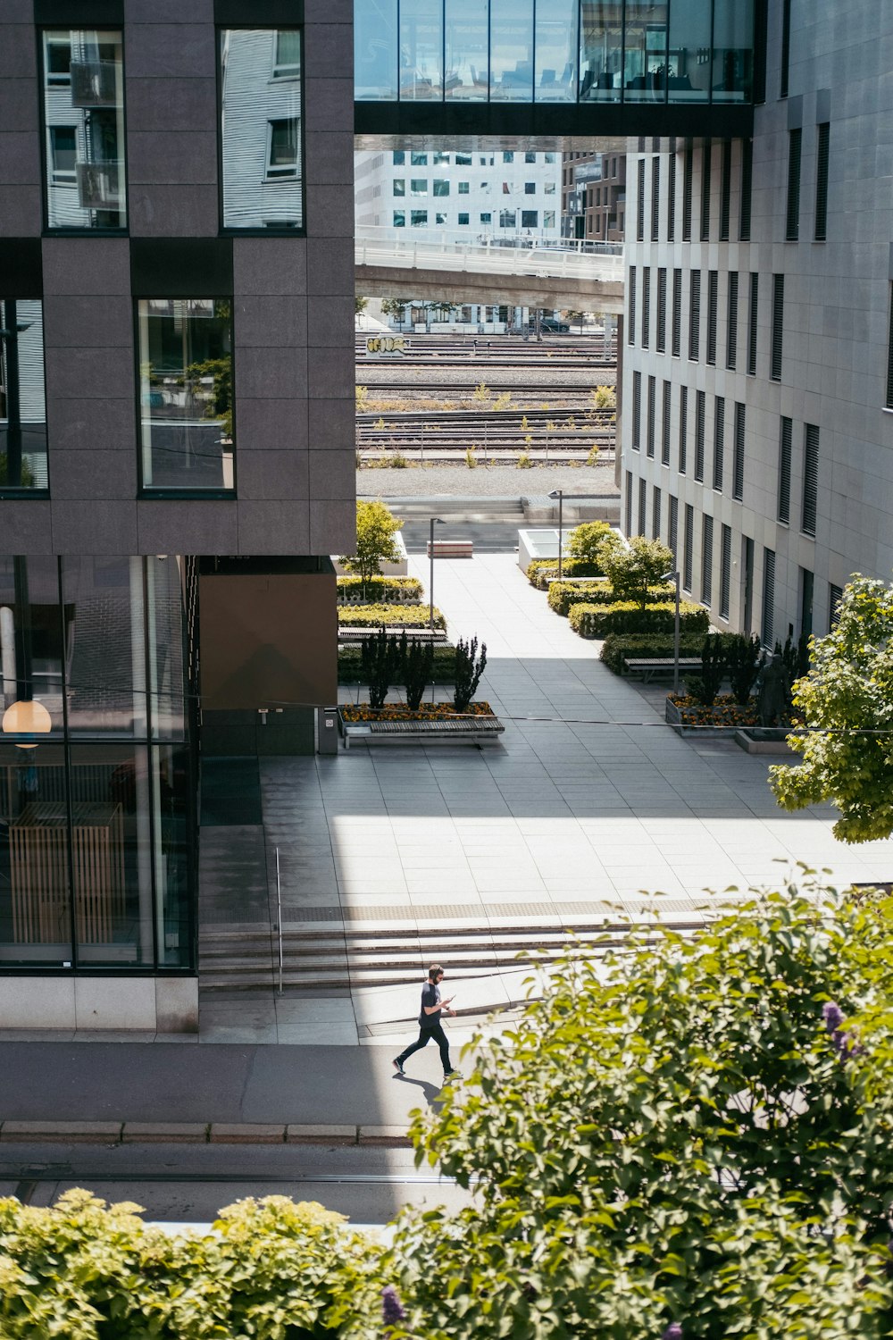 a man walking down a street next to tall buildings