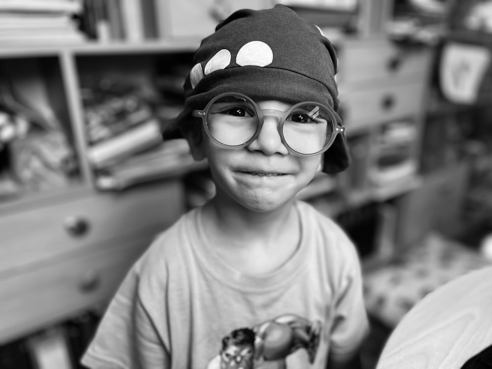 a young boy wearing glasses and a hat