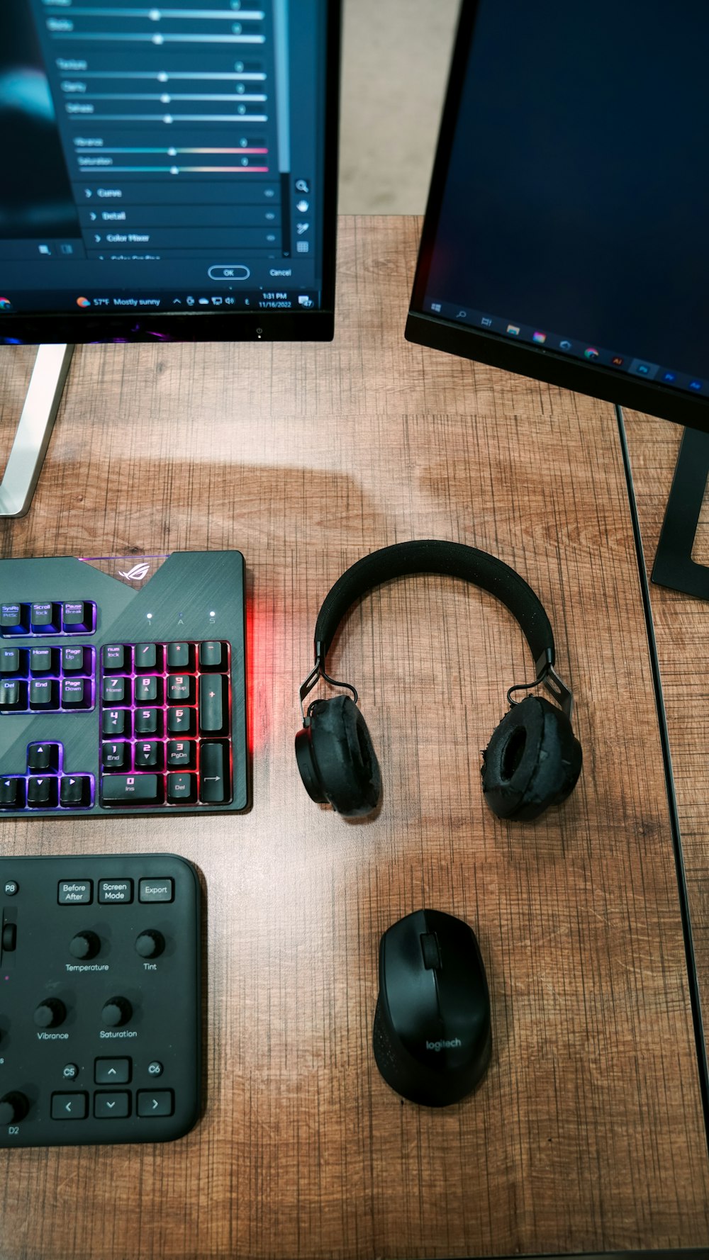 a desk with a keyboard, mouse and headphones