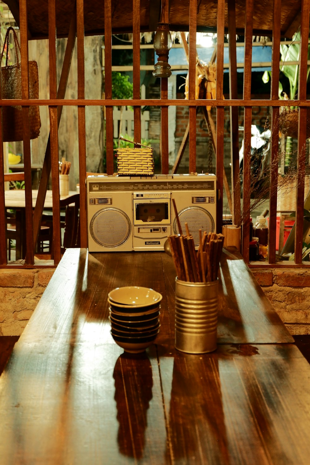 a wooden table topped with a radio next to a stack of plates