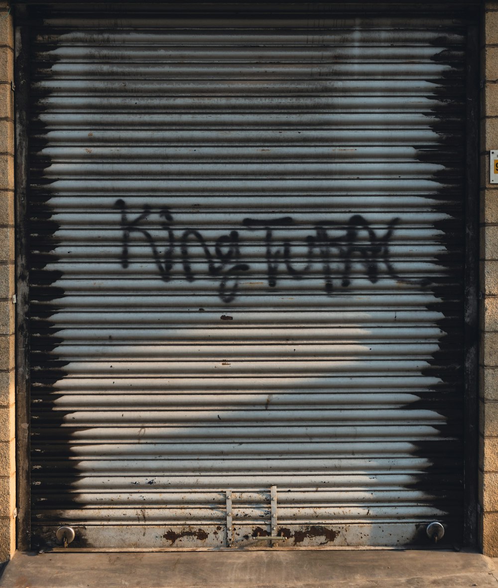 a garage door with graffiti written on it