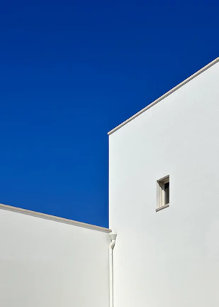 A minimalist urban scene with cool blue hues and sharp contrasts highlighting architectural lines.