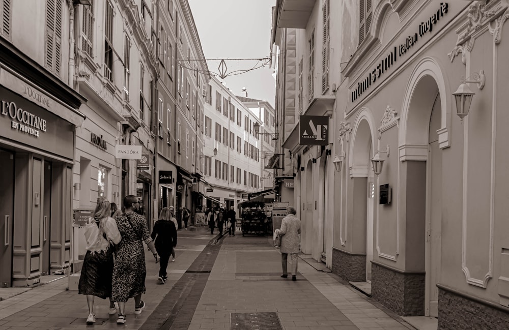 a group of people walking down a street next to tall buildings