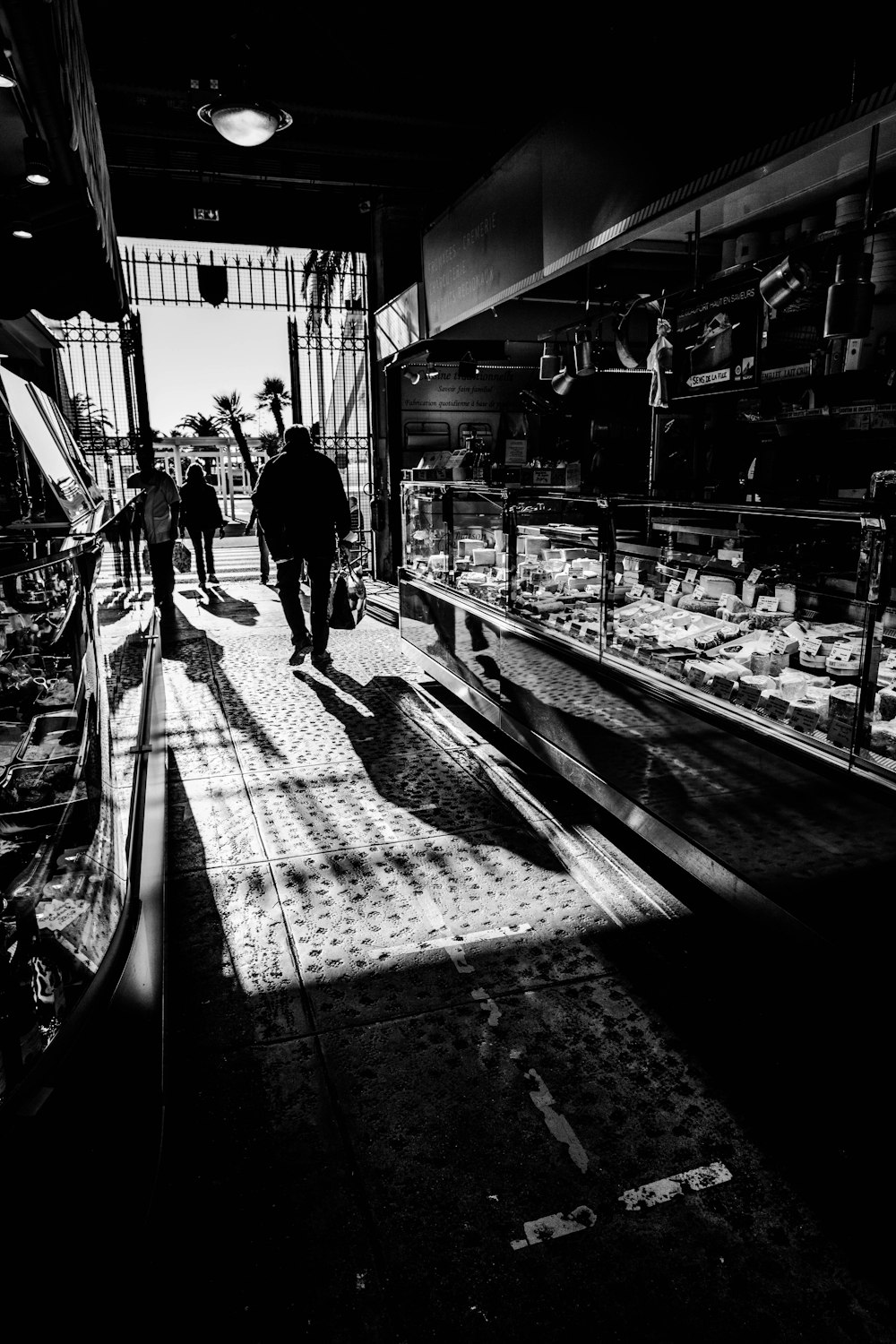 a black and white photo of people walking through a market