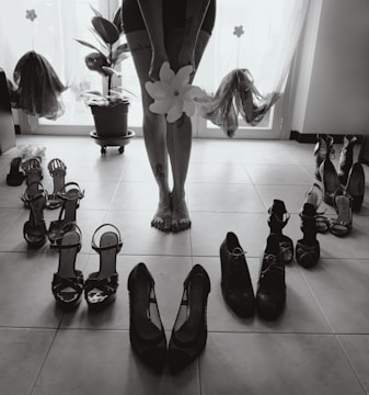 a person standing in front of a bunch of shoes
