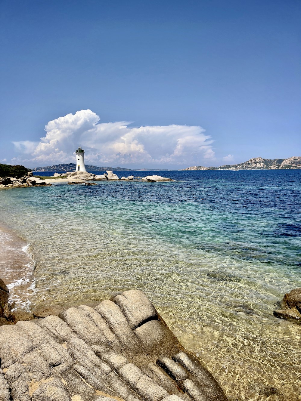 a lighthouse on a rocky shore near the ocean