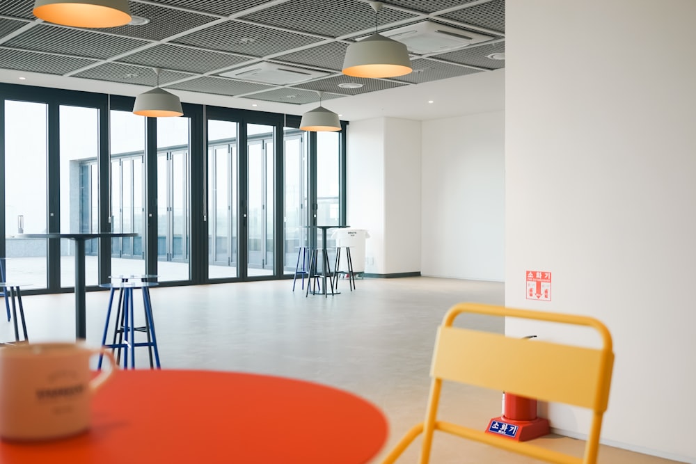 a room with a table, chairs, and a large window