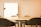 A meeting room with a large conference table surrounded by several black chairs. A whiteboard is mounted on the wall in the background, providing a professional setting.