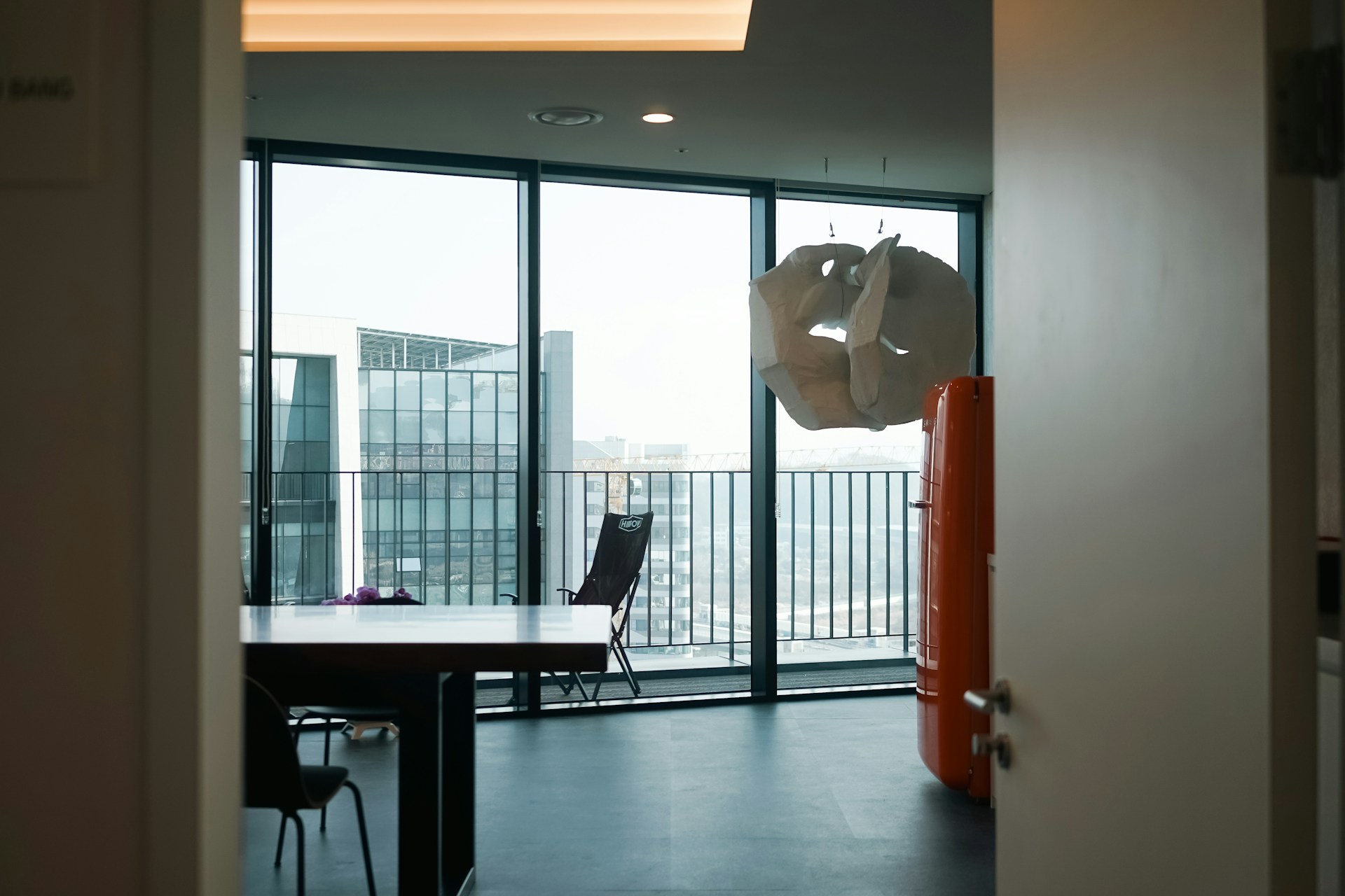 a room with a table, chairs, and a large window