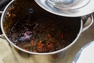 Close-up of a stainless steel saucepan simmering a colorful vegetable stew.