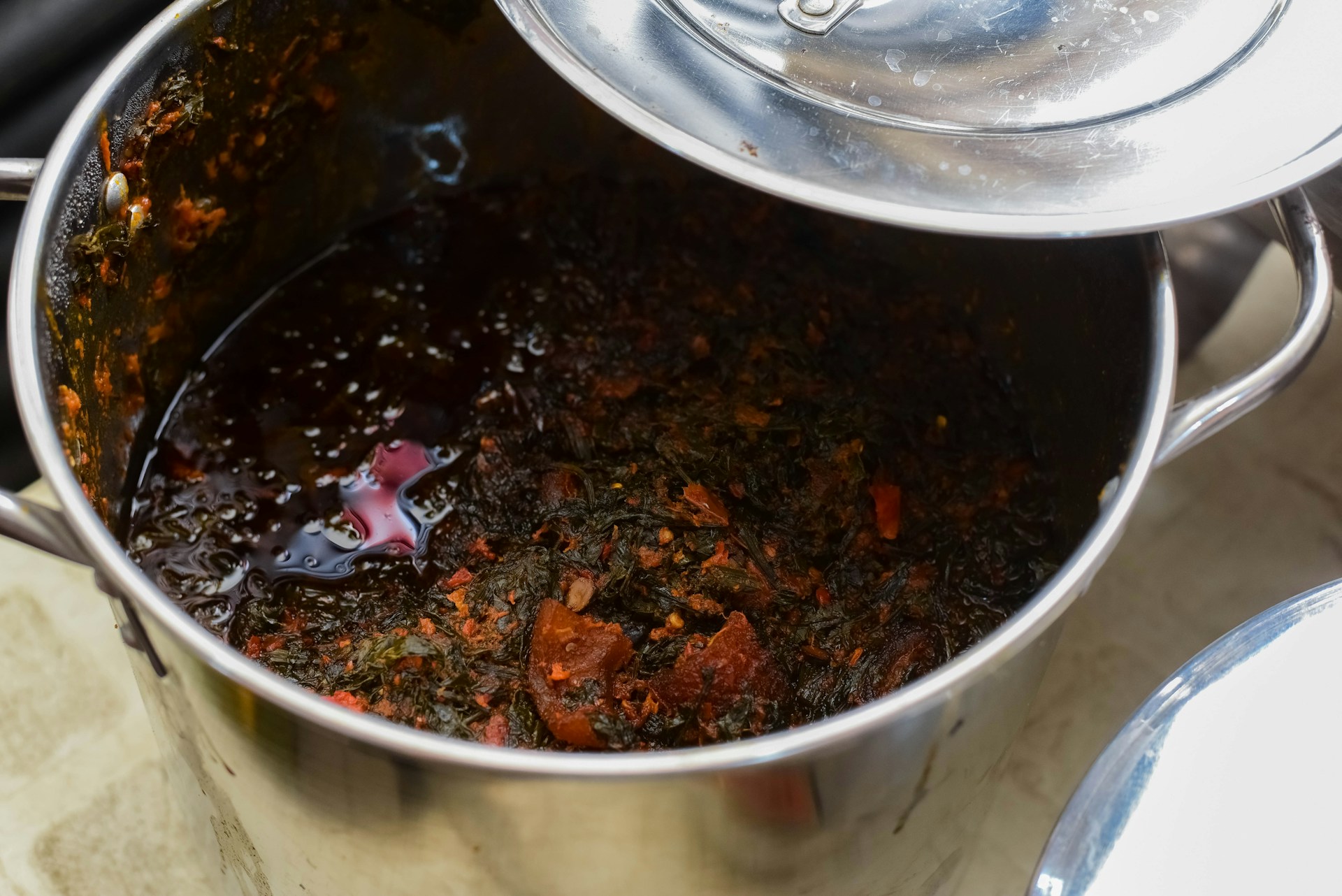 A sleek stainless steel pot gleaming under soft studio lighting, highlighting its polished finish and sturdy handles.