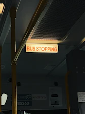 City bus stopping at a well-marked bus stop with passengers boarding.