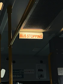 City bus stopping at a well-marked bus stop with passengers boarding.