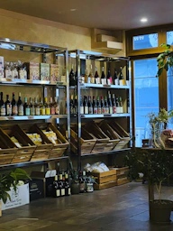 Cozy tasting room at vins-go with bottles of wine lined up on wooden shelves and a welcoming counter.