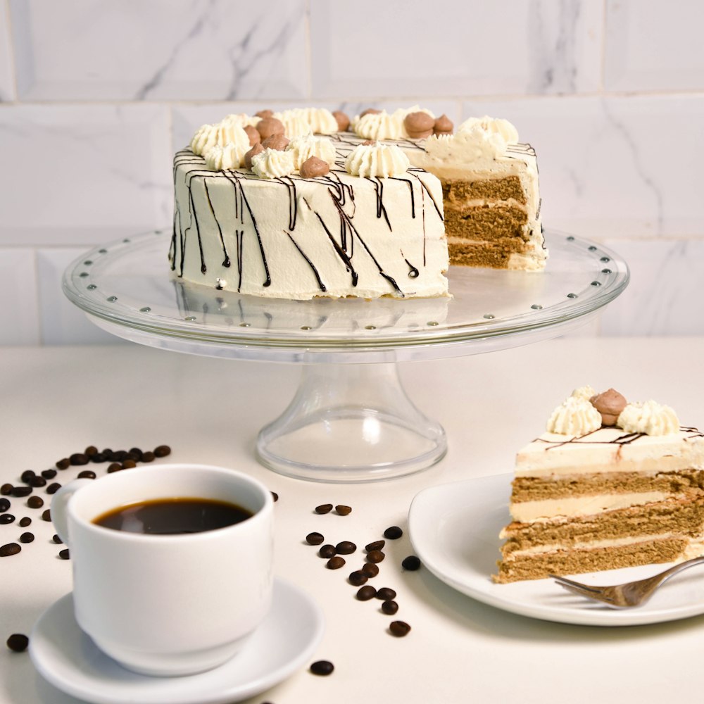 a slice of cake on a plate next to a cup of coffee