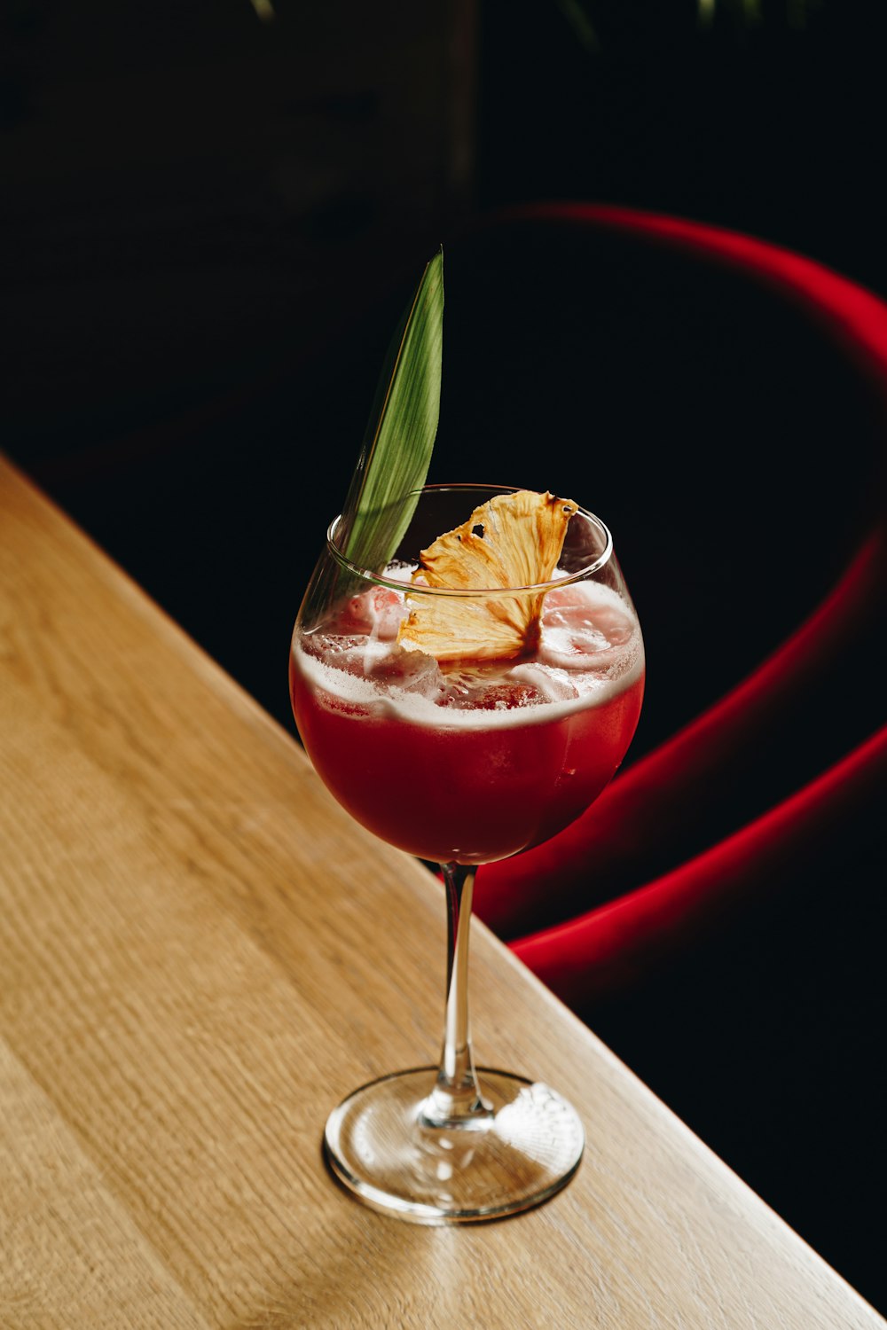 a glass filled with a drink sitting on top of a wooden table