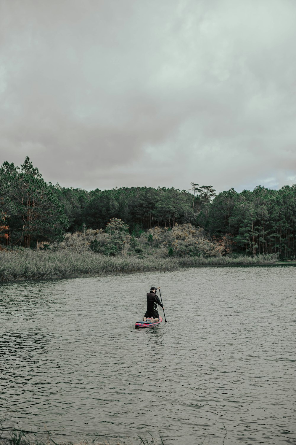 Ein Mann, der auf einem Paddelbrett auf einem See fährt