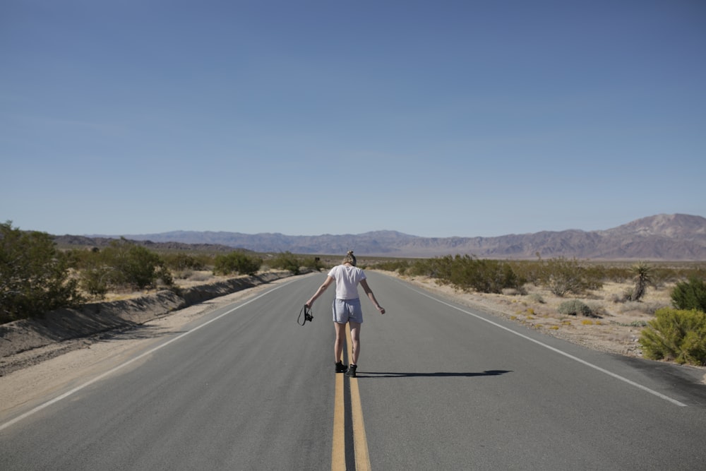 a man riding a skateboard down the middle of a road