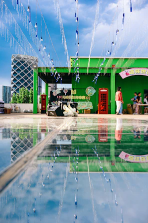 A sleek 360 videobooth setup glowing softly at a lively outdoor evening party