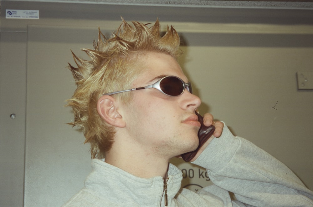 a man with spiked hair talking on a cell phone