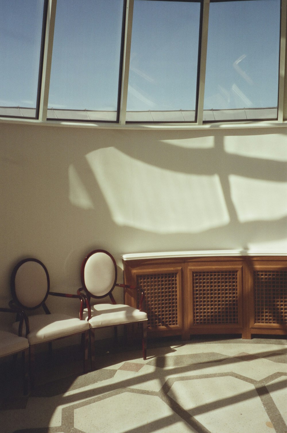 a room with a lot of windows and some chairs