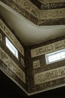 Golden Arabic calligraphy ornamenting an ancient building facade.
