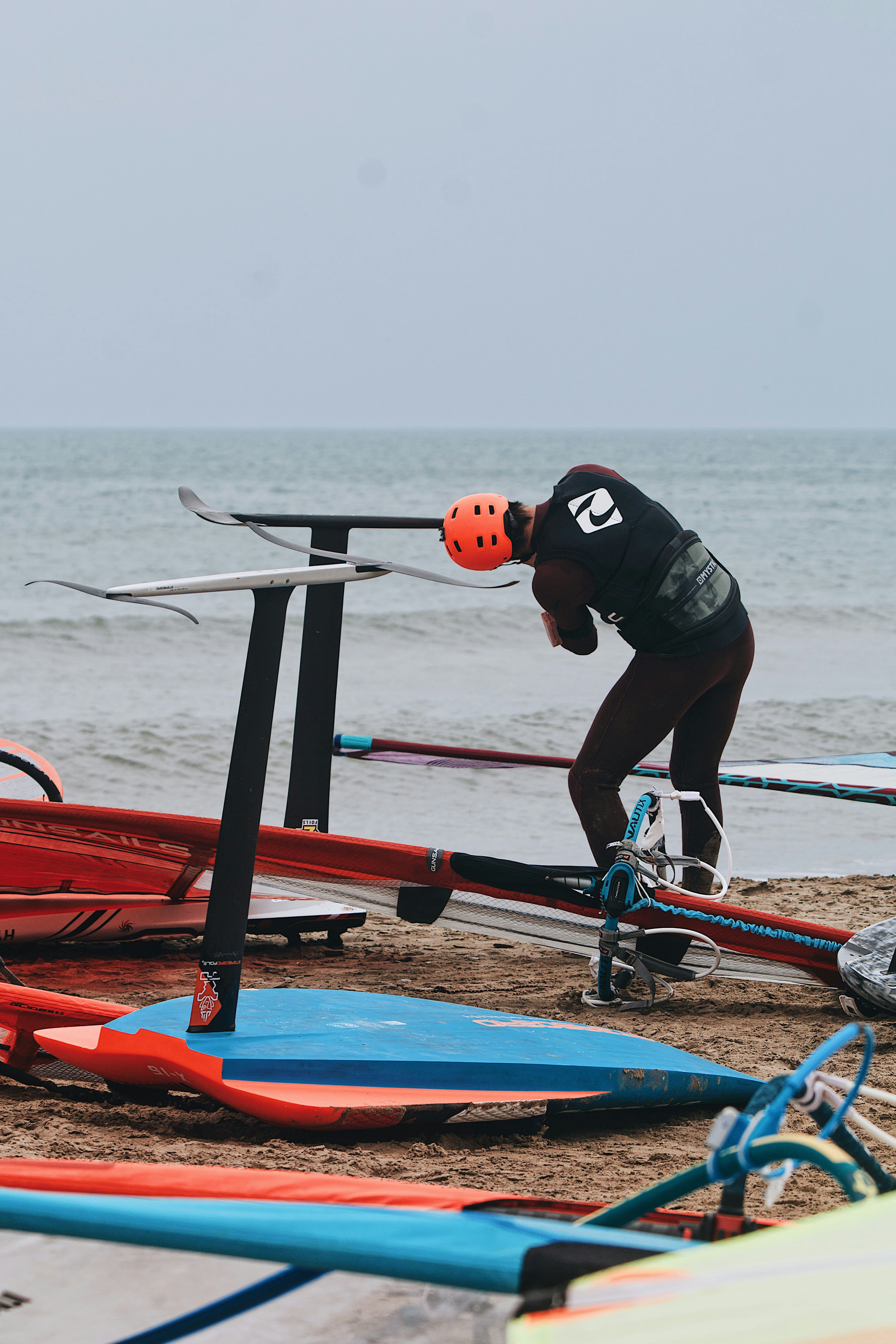 a man bending over to pick up a surfboard