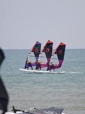 a group of people wind surfing in the ocean