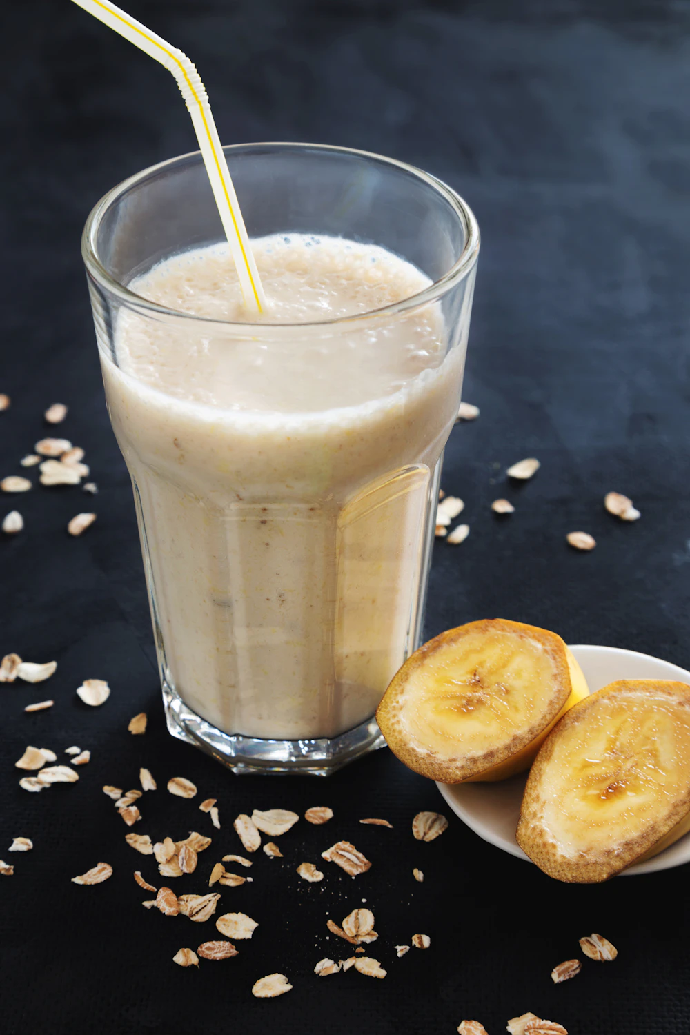 Tall glass of creamy banana smoothie with sliced banana