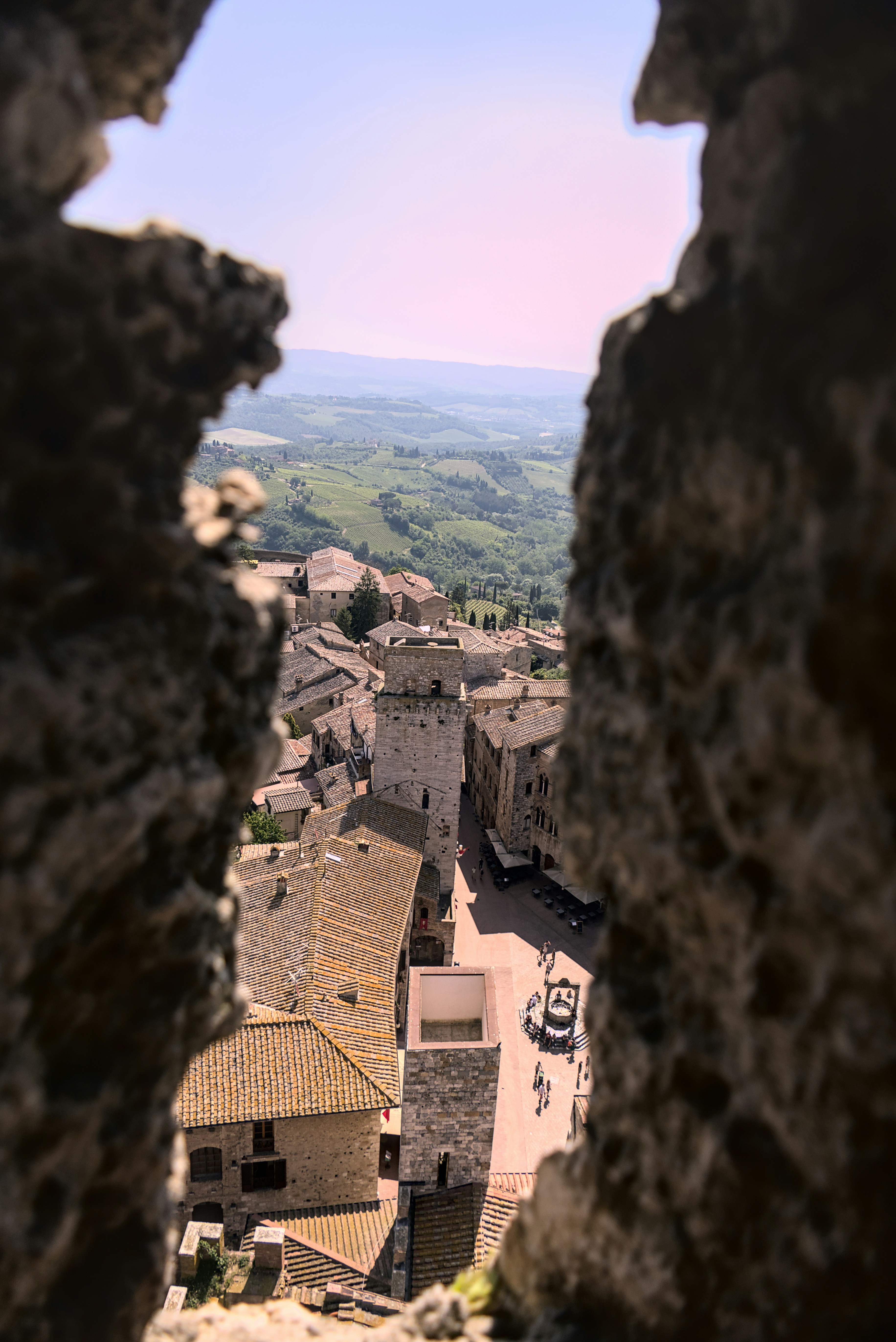 a view of a town through a hole in a rock wall