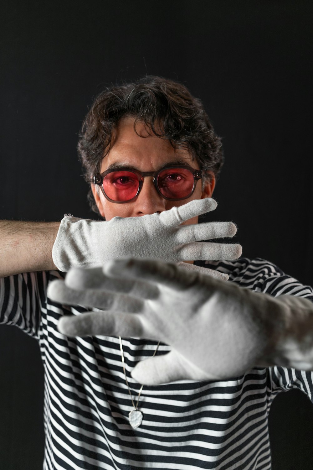 a man in a striped shirt and white gloves