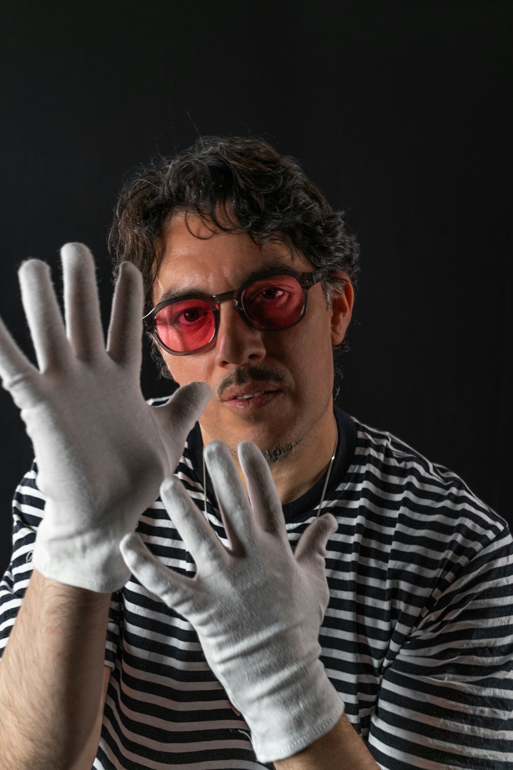 a man in a striped shirt and white gloves