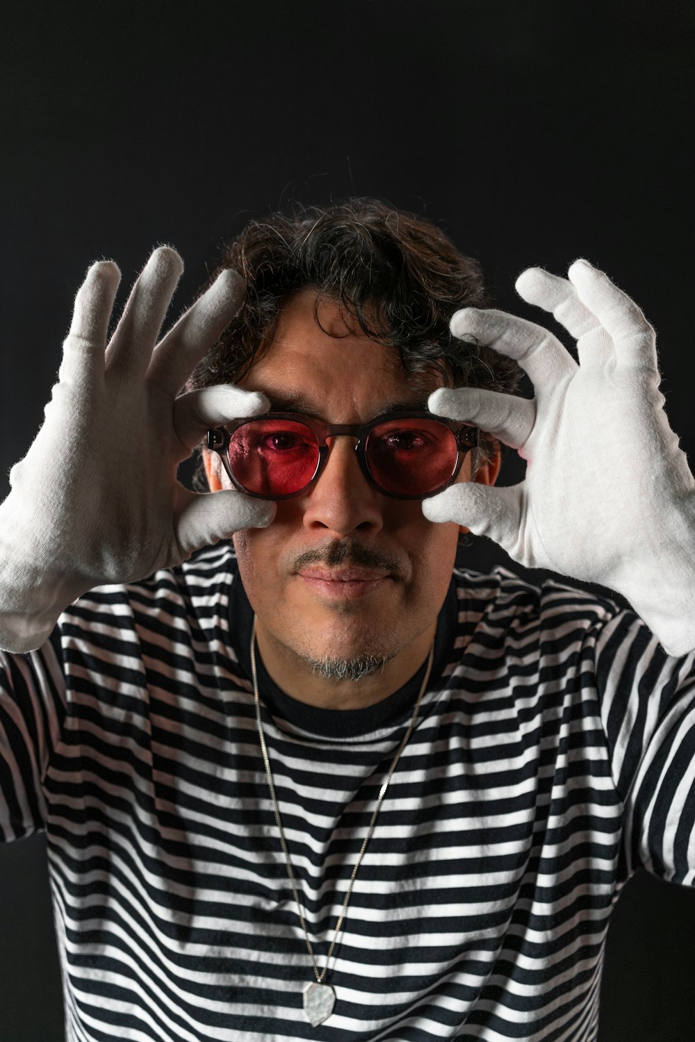 a man wearing white gloves and red glasses