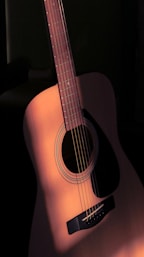 a close up of a guitar with a black background