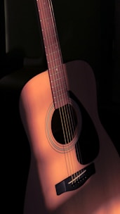a close up of a guitar with a black background