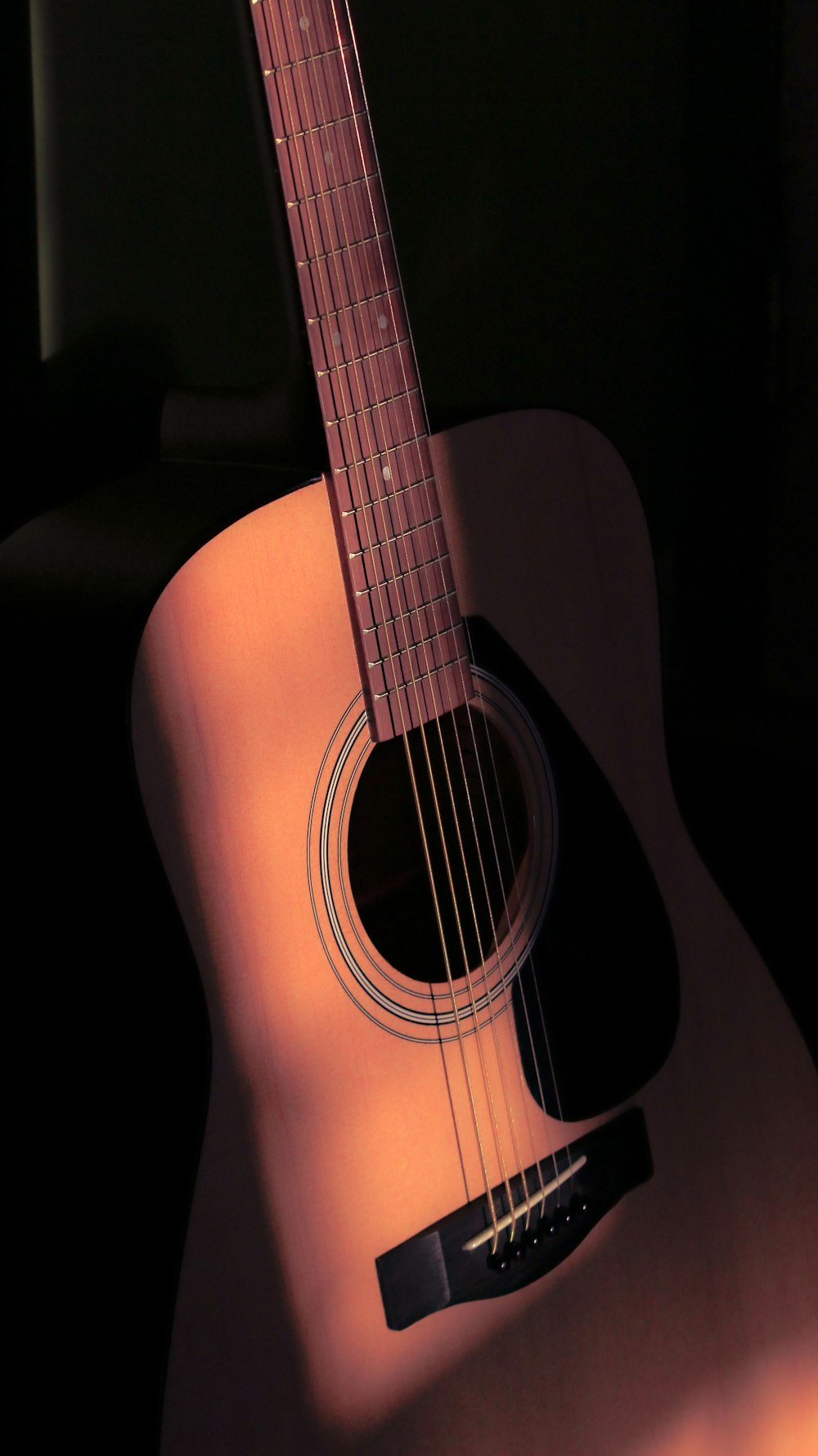 a close up of a guitar with a black background