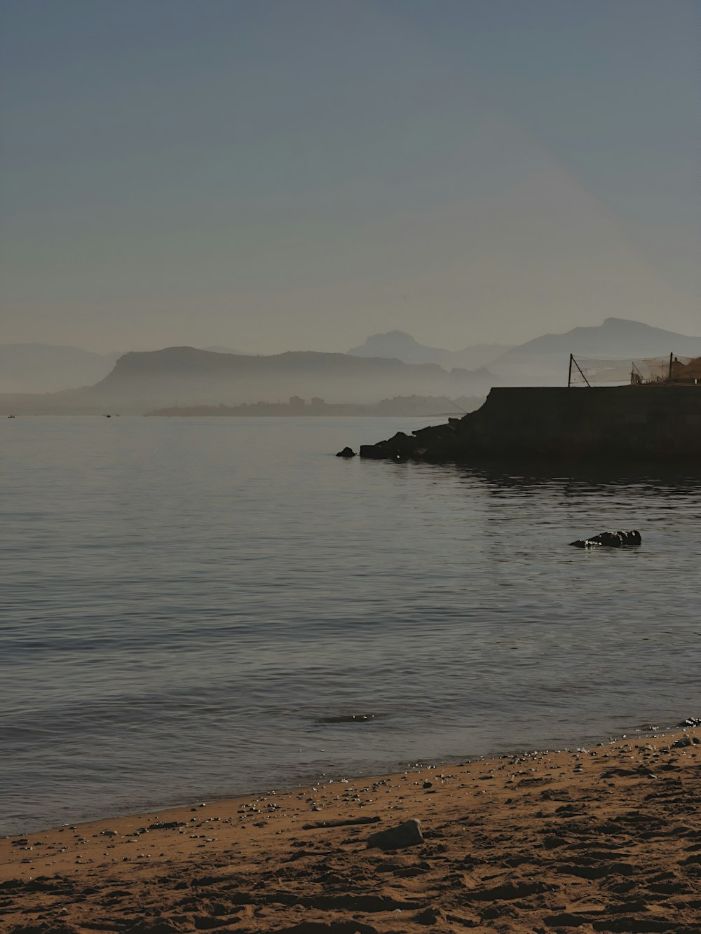 a person walking on a beach next to the ocean