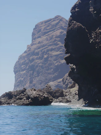 a large rock formation in the middle of a body of water